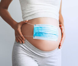 pregnant lady with surgical mask on her tummy