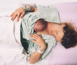 woamn with newborn baby on her hug